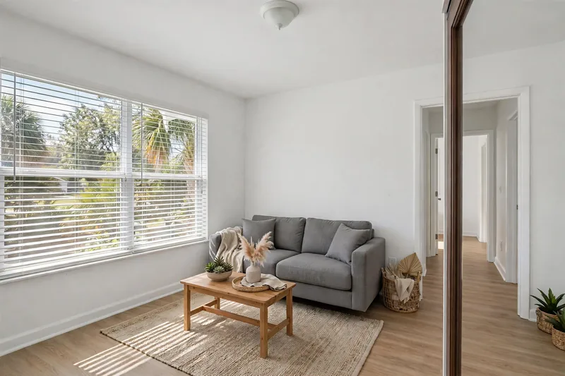 Illustration of the same living room after the work, clean and bright with the wall repaired